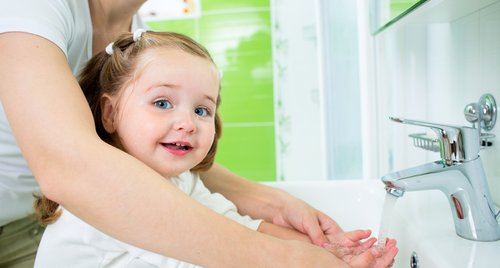Mother washing kid hands (hand washing) which is very important to prevent infections.
