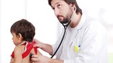 Young doctor examining little boy in hospital